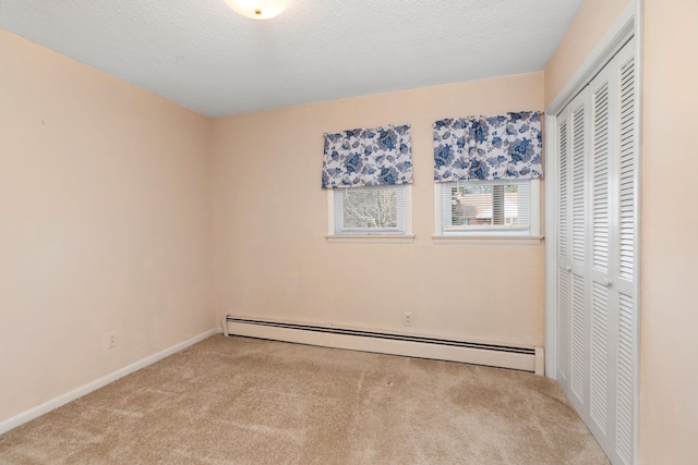 unfurnished bedroom featuring a textured ceiling, carpet, a closet, and a baseboard radiator