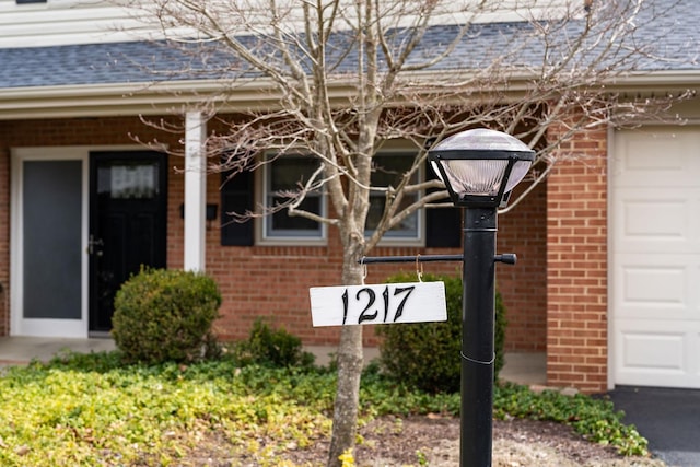 exterior details with brick siding and a shingled roof