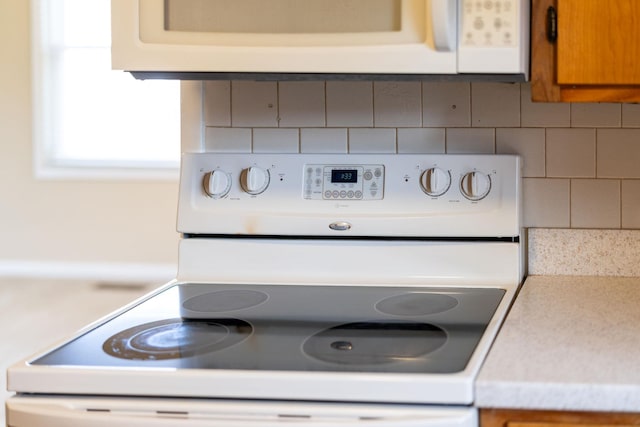 room details with white appliances, backsplash, brown cabinets, and light countertops