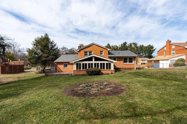 back of property featuring a yard, brick siding, and a chimney