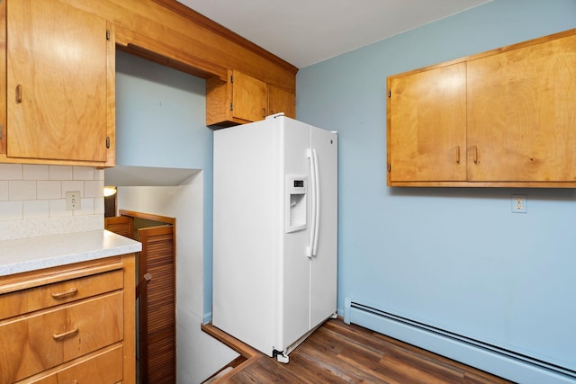 kitchen with tasteful backsplash, dark wood finished floors, light countertops, baseboard heating, and white fridge with ice dispenser