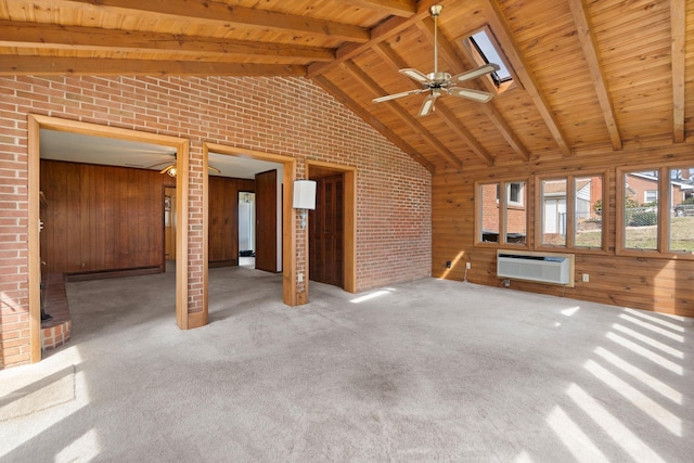 unfurnished living room featuring wooden walls, baseboard heating, wooden ceiling, and a skylight