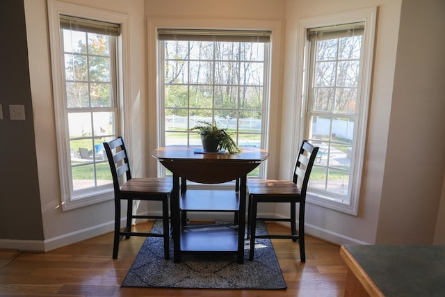 dining area featuring a wealth of natural light, baseboards, and wood finished floors