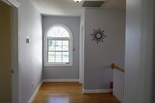 interior space featuring wood finished floors, visible vents, and baseboards