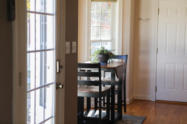 dining space featuring wood finished floors and baseboards