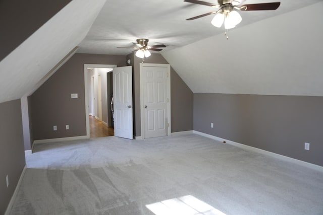 additional living space featuring light carpet, ceiling fan, lofted ceiling, and baseboards