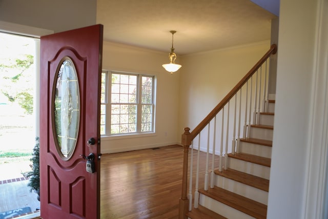 entrance foyer featuring stairway, baseboards, ornamental molding, and wood finished floors