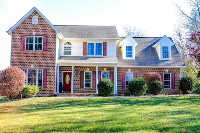 view of front of property featuring a front yard and brick siding