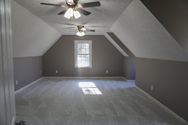 bonus room featuring vaulted ceiling, a textured ceiling, carpet, and baseboards