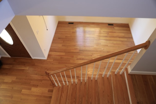 stairs with visible vents, baseboards, and wood finished floors