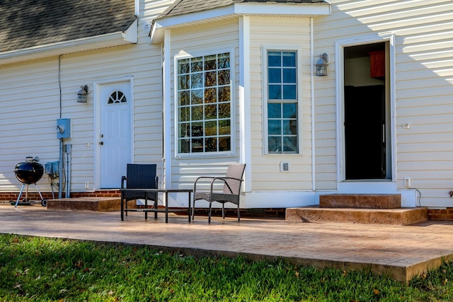 doorway to property with roof with shingles