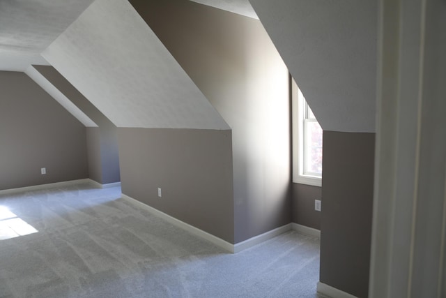 additional living space featuring lofted ceiling, carpet, and baseboards