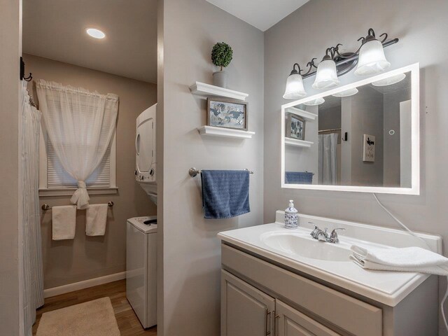 bathroom with vanity, stacked washer and dryer, and wood-type flooring