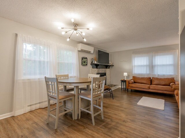 dining area with plenty of natural light, a chandelier, hardwood / wood-style floors, and a wall unit AC