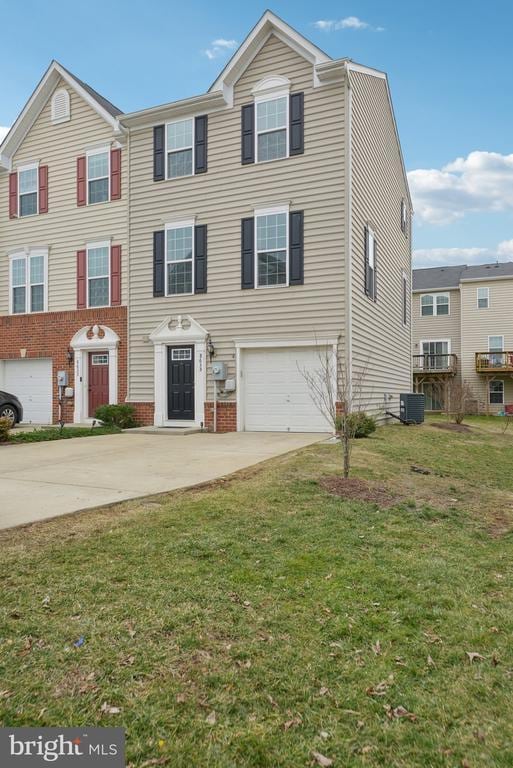 multi unit property featuring brick siding, an attached garage, a front yard, cooling unit, and driveway