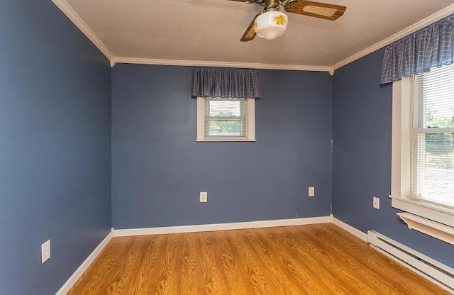 spare room with crown molding, plenty of natural light, hardwood / wood-style floors, and baseboard heating