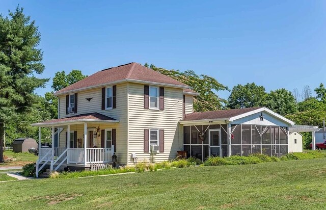 exterior space featuring a sunroom, a front yard, and covered porch