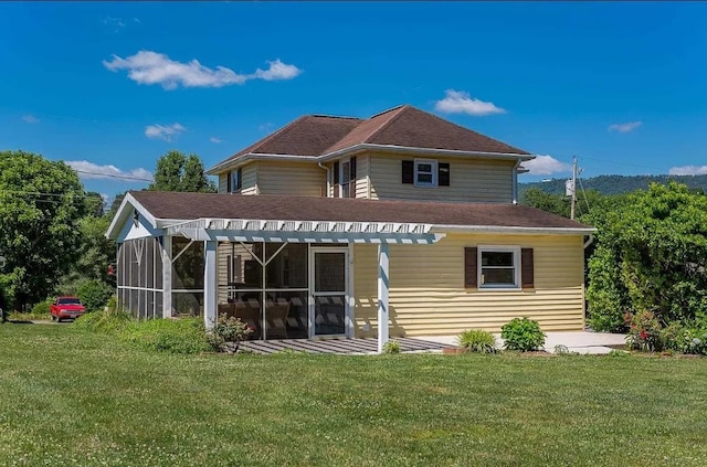 back of property featuring a sunroom and a lawn