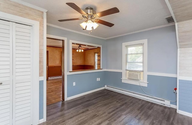 unfurnished room featuring dark hardwood / wood-style flooring, a baseboard heating unit, crown molding, and a textured ceiling