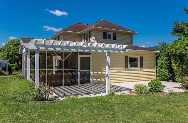 back of house featuring a sunroom and a yard