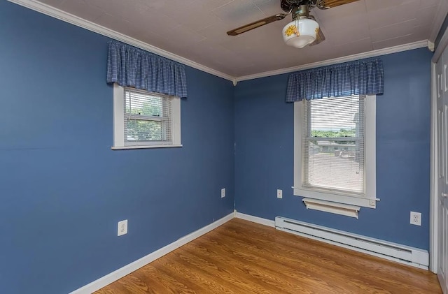 empty room with baseboard heating, ornamental molding, wood-type flooring, and plenty of natural light