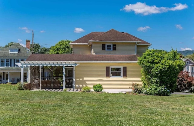 rear view of house with a pergola and a lawn