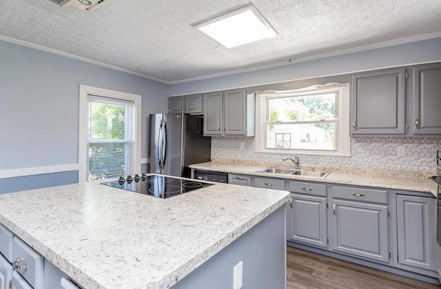 kitchen with gray cabinets, a center island, sink, and black appliances