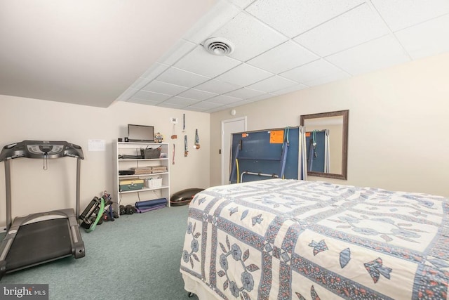 carpeted bedroom with visible vents and a drop ceiling