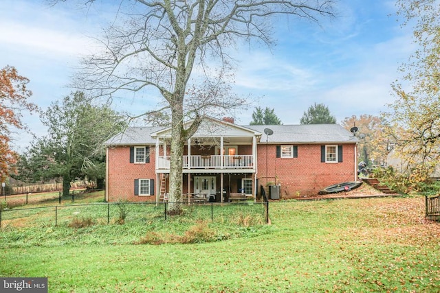 back of house featuring central air condition unit, a yard, fence, and brick siding