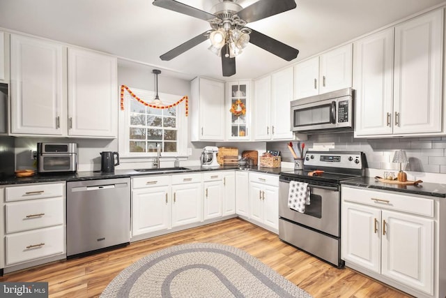 kitchen featuring white cabinets, appliances with stainless steel finishes, and a sink