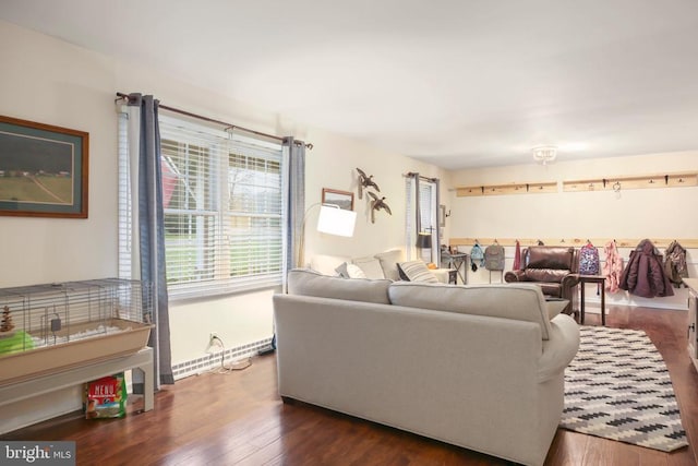 living room with dark wood-type flooring and baseboard heating