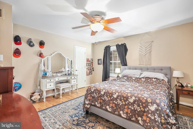 bedroom featuring visible vents, ceiling fan, and wood finished floors