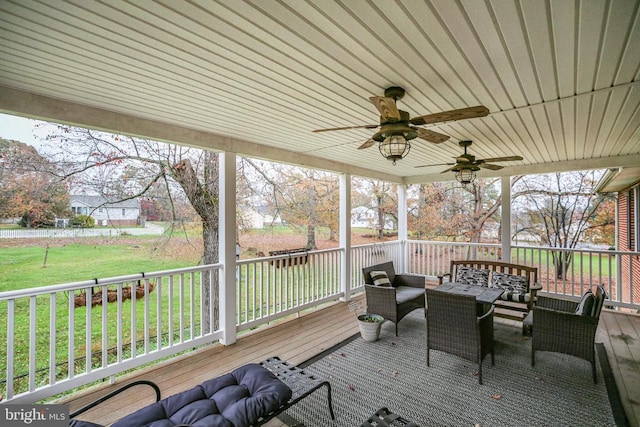 wooden deck featuring an outdoor living space, a lawn, and ceiling fan