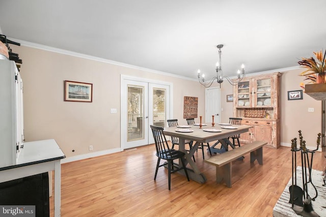 dining area featuring french doors, a notable chandelier, and ornamental molding