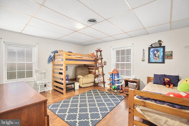 bedroom featuring visible vents, a paneled ceiling, and wood finished floors