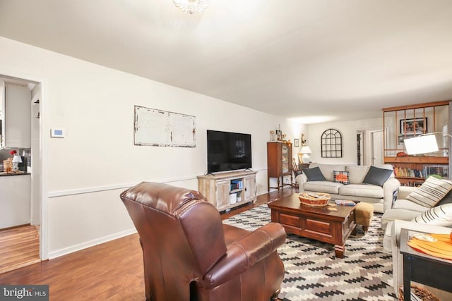 living area with baseboards and wood finished floors