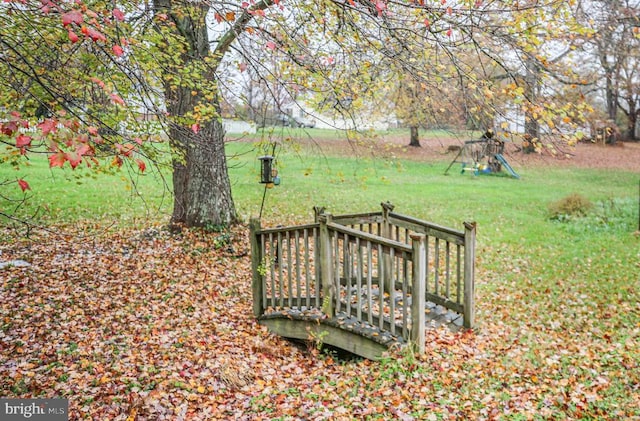 view of yard featuring a wooden deck and a playground