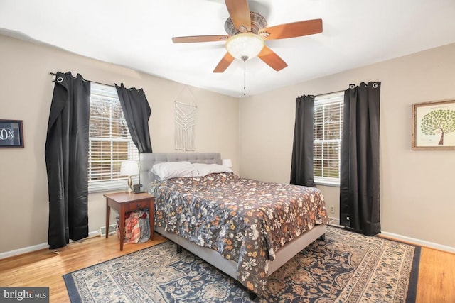 bedroom featuring a ceiling fan, baseboards, and wood finished floors