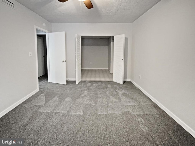 unfurnished bedroom featuring ceiling fan, carpet, a textured ceiling, and a closet