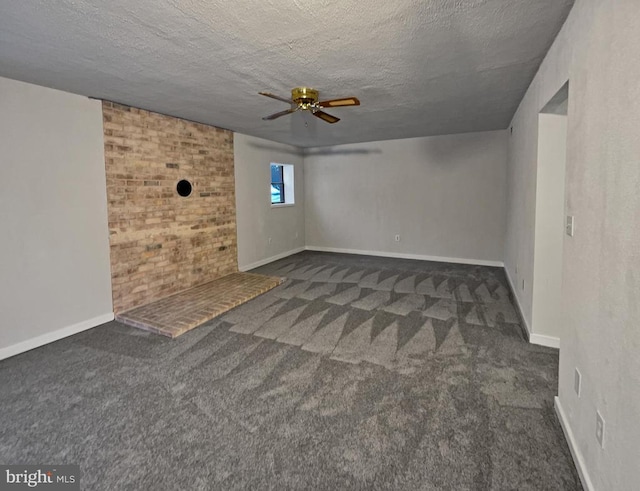 unfurnished room featuring ceiling fan, brick wall, dark carpet, and a textured ceiling