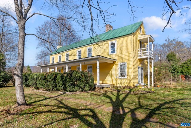 exterior space with a balcony and a front lawn