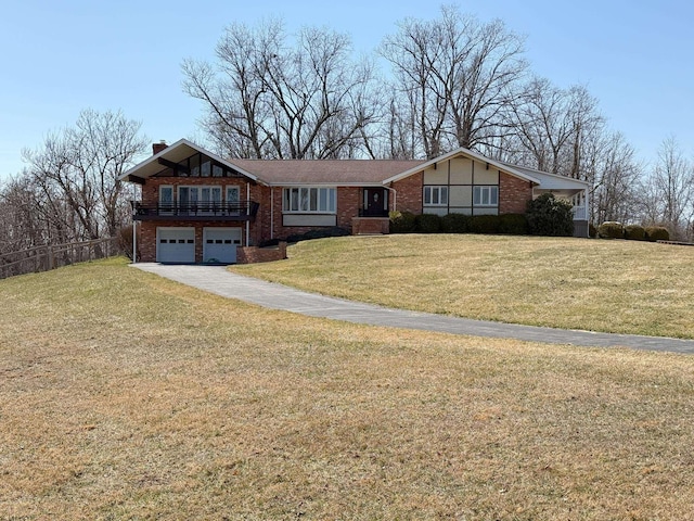 view of front facade with brick siding, a front yard, a chimney, a garage, and driveway