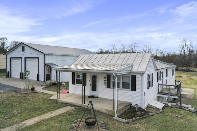 view of front of house featuring a garage, metal roof, a front lawn, and a standing seam roof