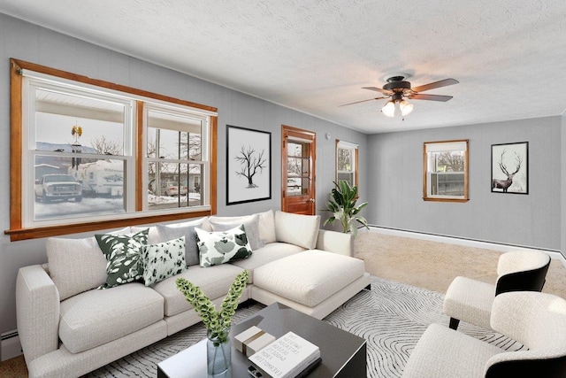 carpeted living room with a baseboard radiator, a ceiling fan, and a textured ceiling