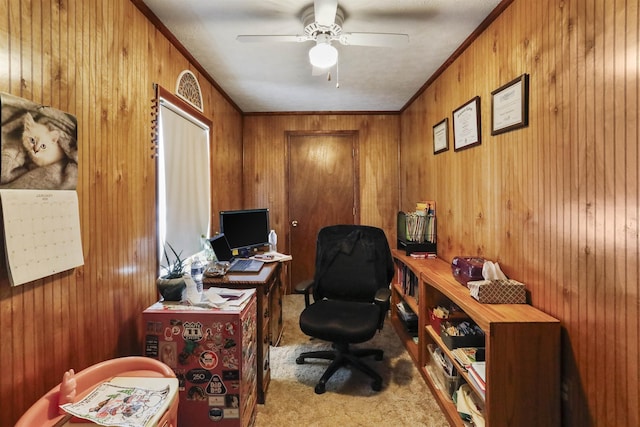 office with ornamental molding, wood walls, carpet flooring, and a ceiling fan