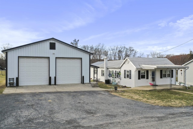 view of front of house with a garage, covered porch, and central AC