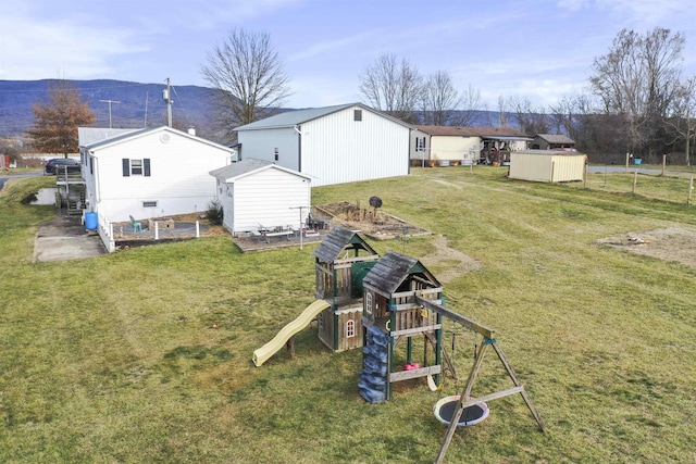 view of yard featuring a shed, a playground, and an outdoor structure