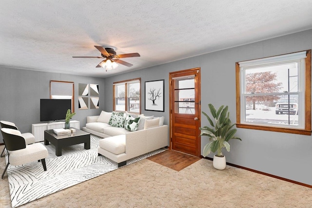 living room with carpet floors, radiator heating unit, ceiling fan, a textured ceiling, and baseboards