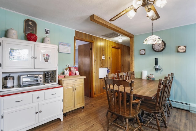 dining space featuring a ceiling fan, a baseboard radiator, visible vents, and wood finished floors