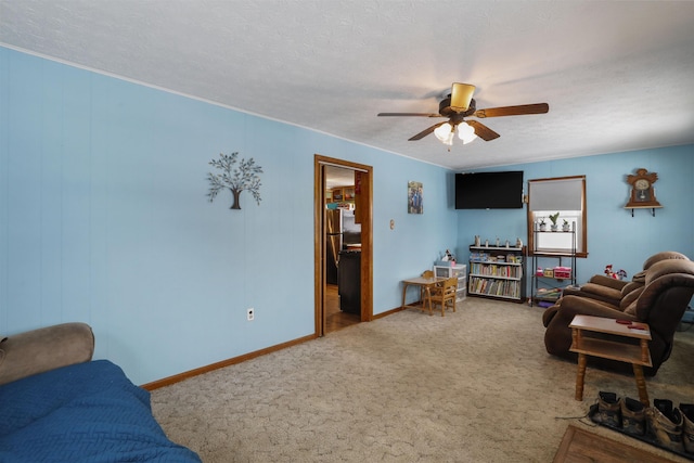 carpeted living room featuring a textured ceiling, ceiling fan, and baseboards